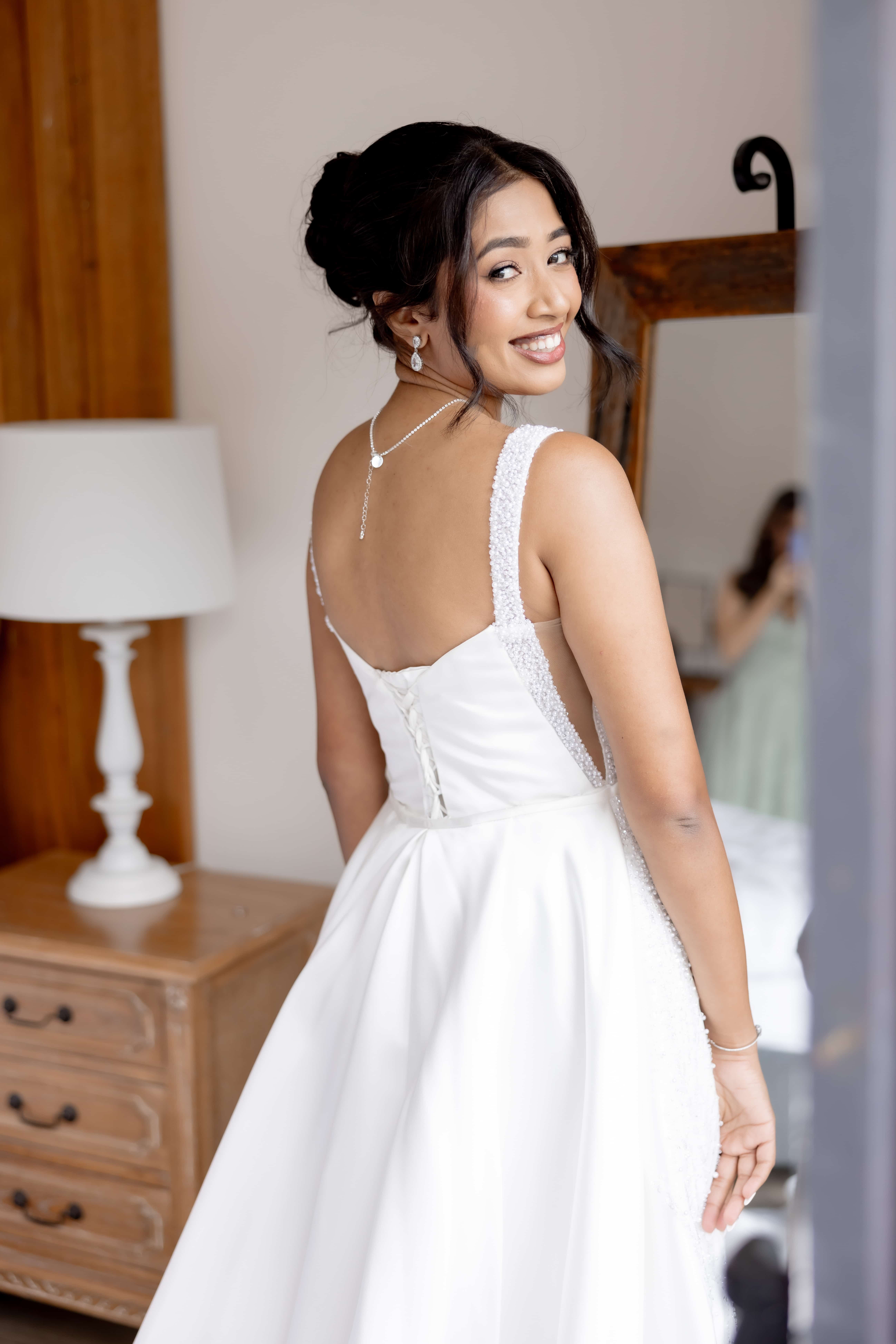 Bride putting on jewellery, soft updo, getting ready