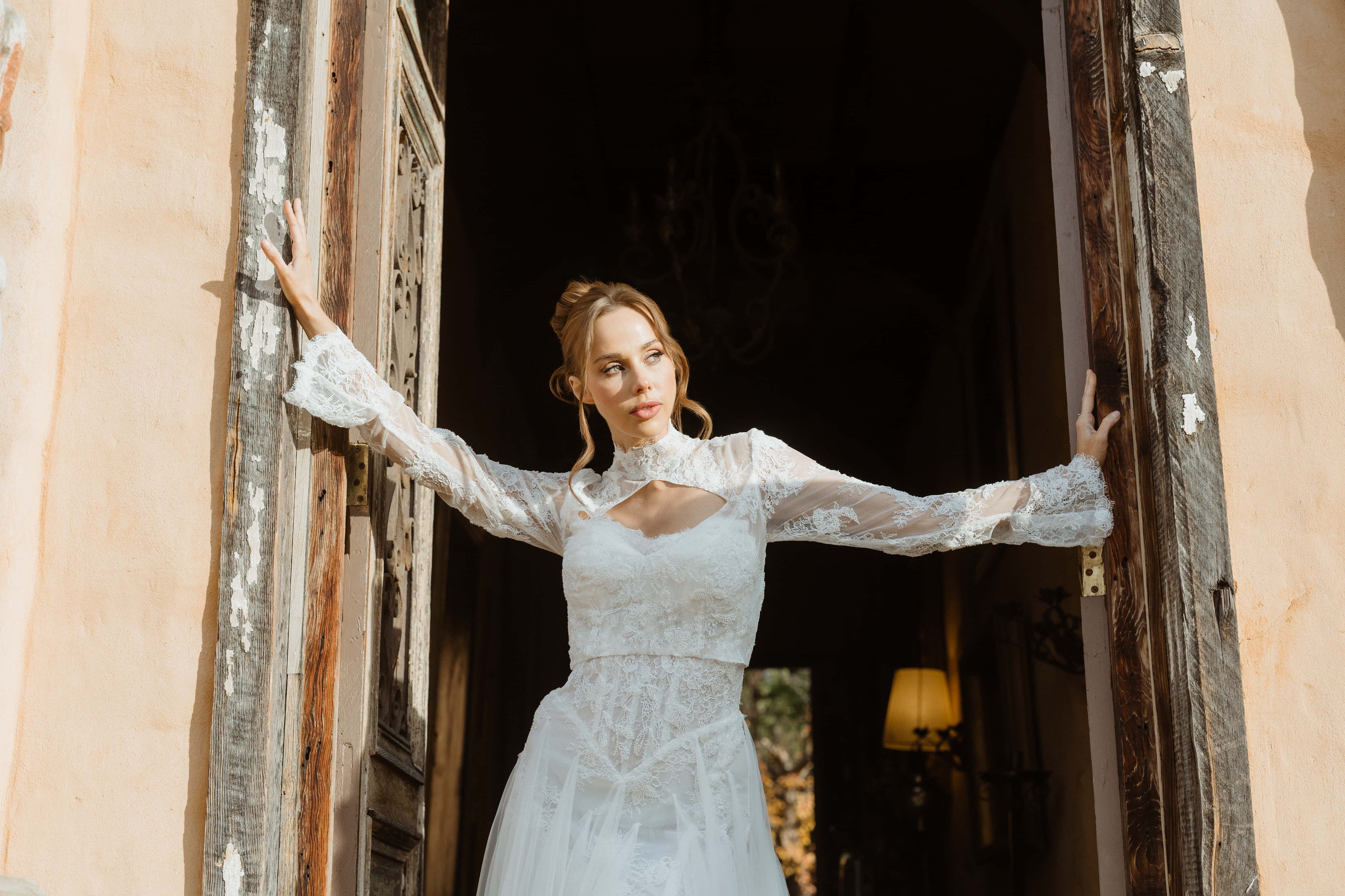 Bride in lace gown at sunlit doorway — Marikate Makeup Melbourne