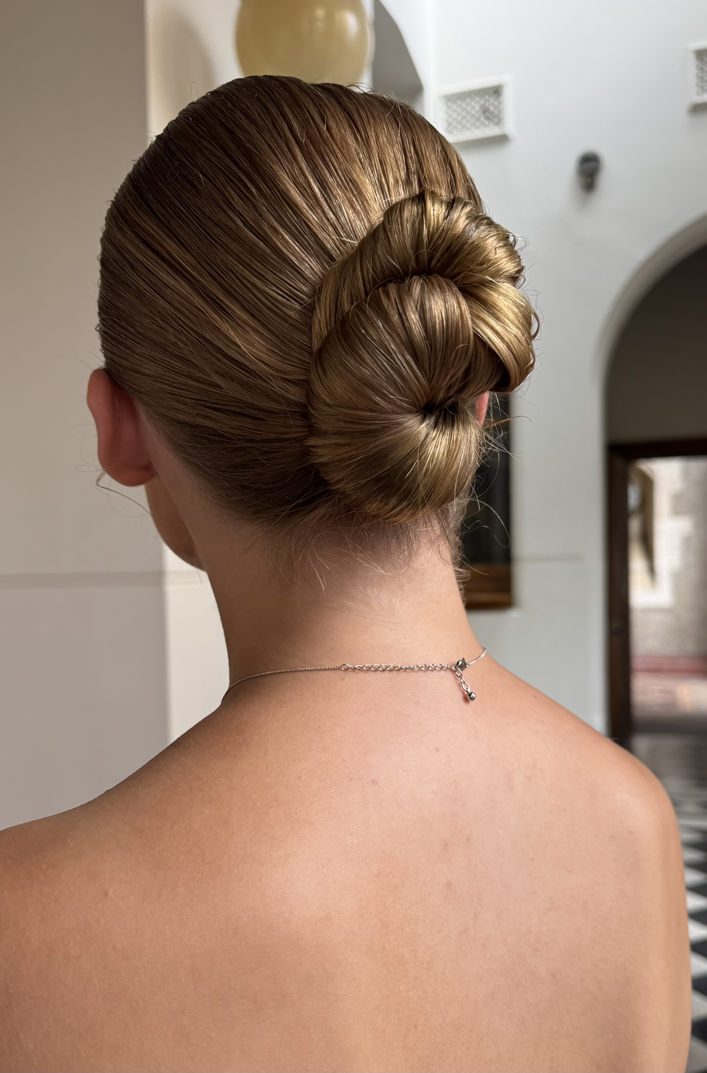 Sleek low chignon bridal hair from behind — Marikate Makeup Melbourne