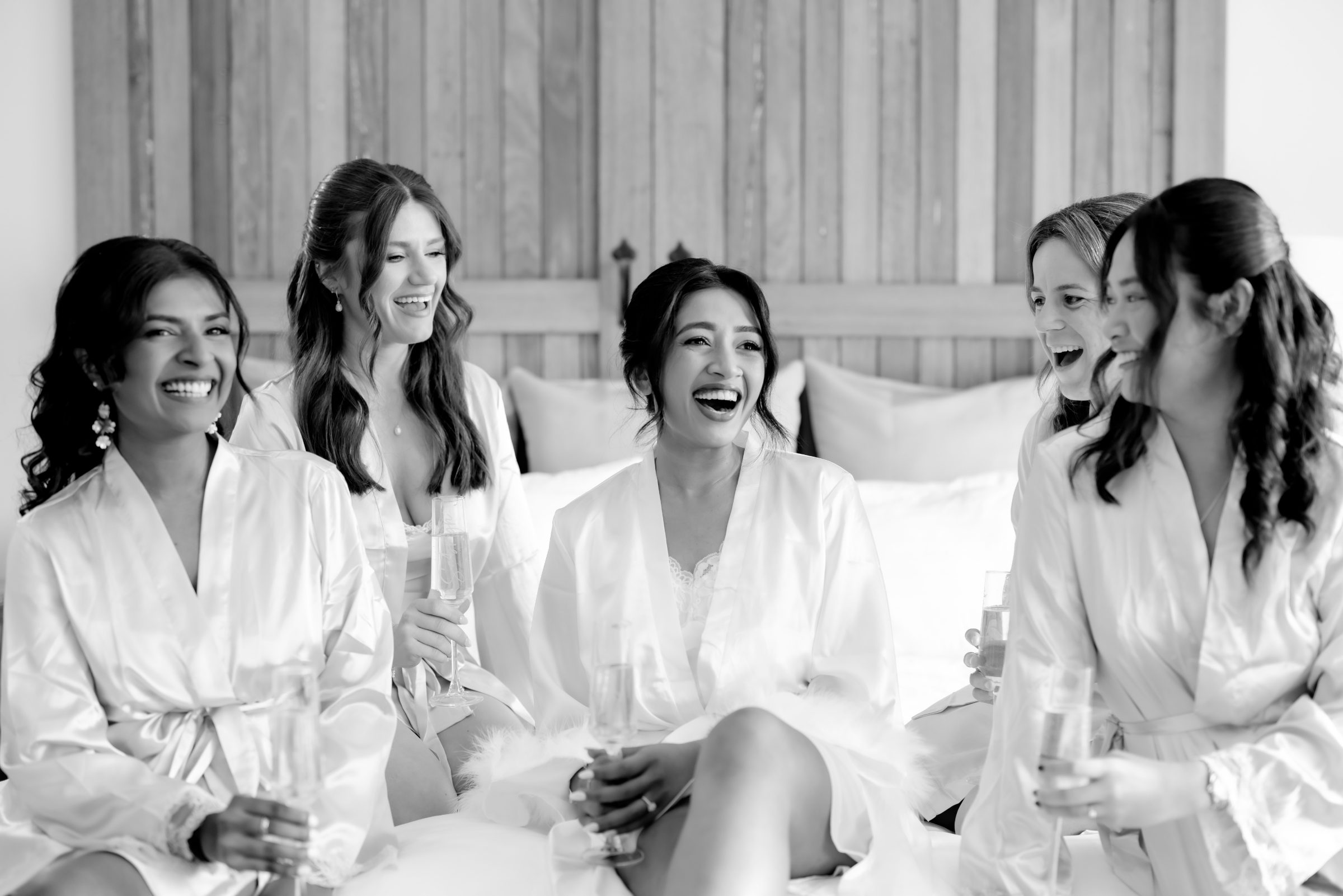 Bride and bridal party laughing in white robes on the wedding morning, Marikate Makeup
